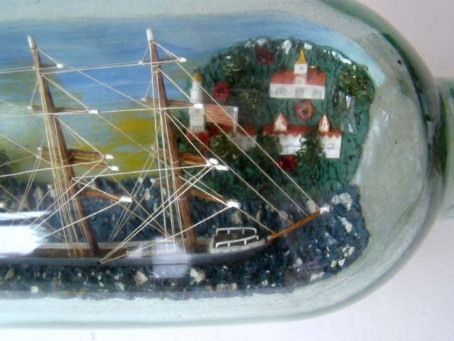 A four masted ship in a bottle flying an American flag with an American coastal town in the background. Circa 1930-1940 — image 4